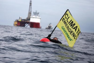 Greenpeace UK campaigner Sarah North holds a banner whilst floating in front of BP rig on day 11 of the protest in the North Sea.